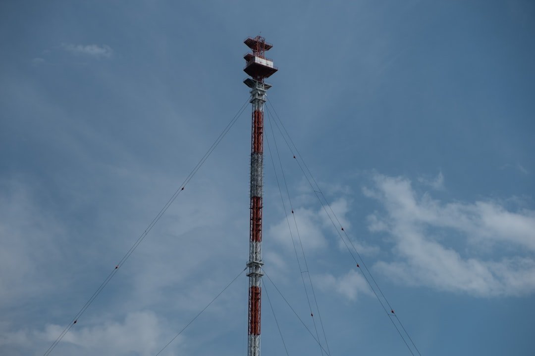 red-and-white-metal-tower-under-blue-sky-takzbbfbds0